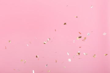 Golden confetti on pink background