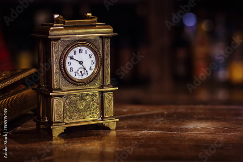 Fototapeta antique clock stand on a wooden table