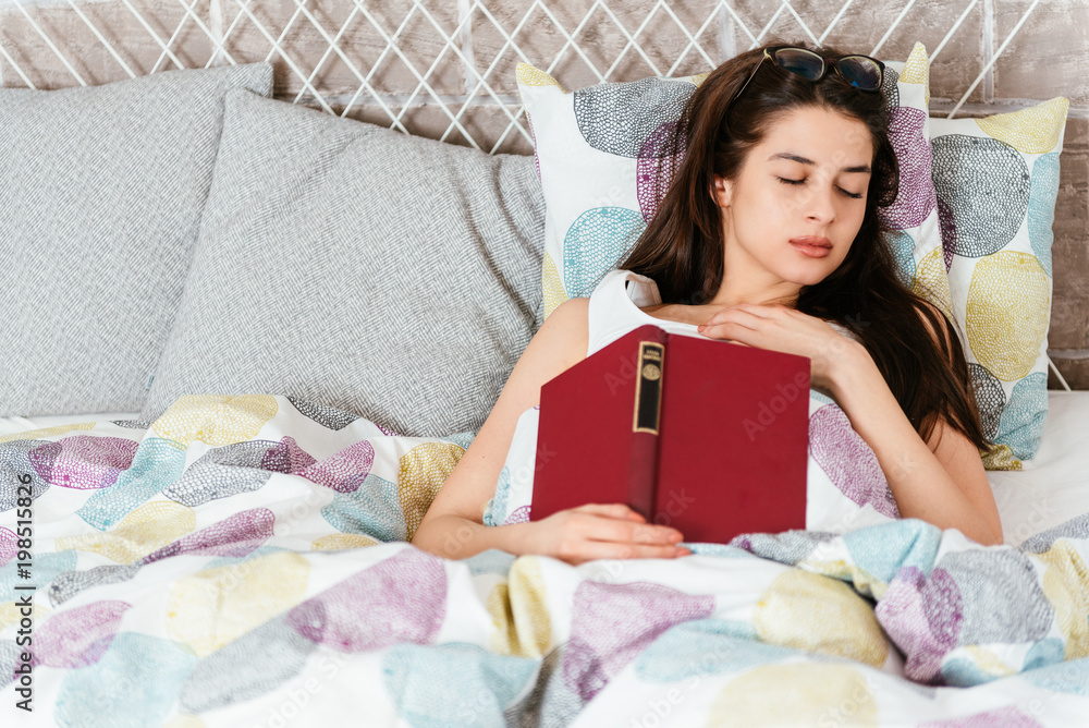 Young beautiful woman falling asleep while reading a book Young beautiful woman falling asleep while reading a book