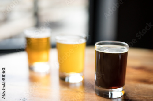 Dark stout ale in front of a flight of beer in a diagonal row