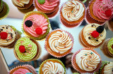 group of tasty cupcakes on a white wooden table