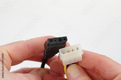 Hands holding 4-pin PC power connectors photo