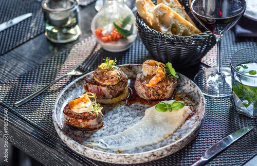 Grilled steak meat with foie gras, shrimp, cheese and glass of red wine