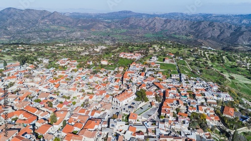 Aerial bird eye view of famous landmark tourist destination valley Pano Lefkara village, Larnaca, Cyprus. Ceramic tiled house roofs, greek orthodox church at south of Troodos hills, Kionia, from above photo