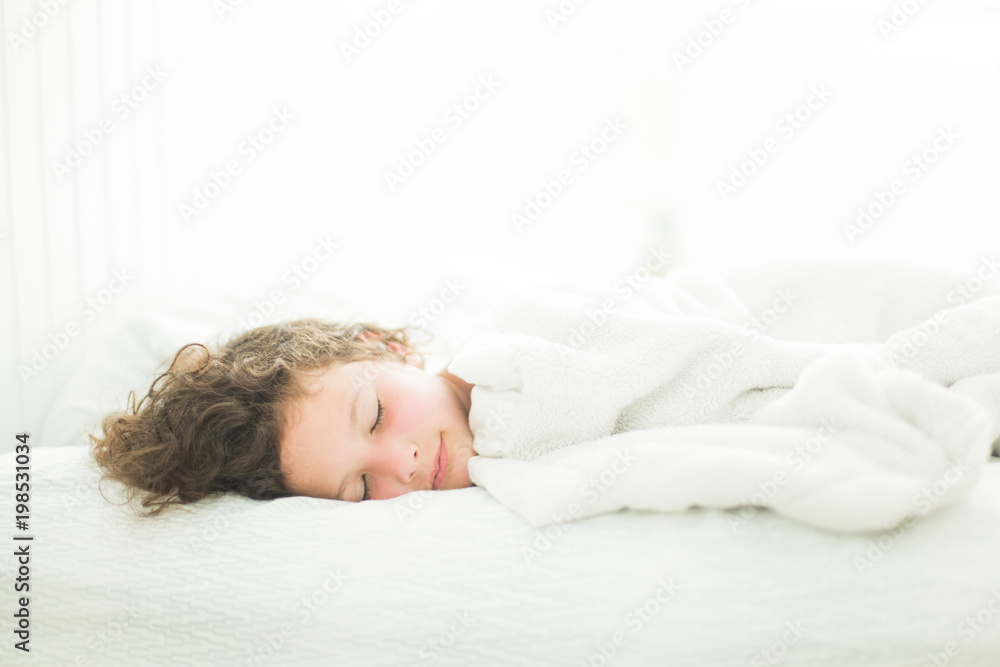 Child asleep in white light-filled bedroom Child asleep in white light-filled bedroom