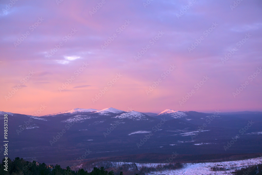 landscape - pink sky over the winter Ural mountains in the early morning