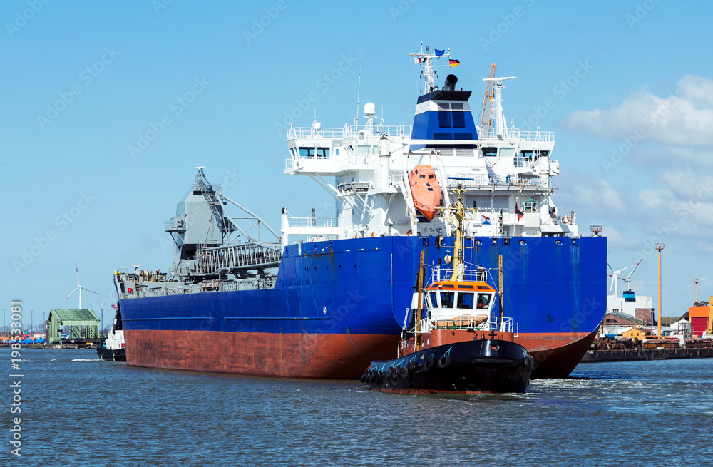 Hafenanlagen von Bremerhaven, Frachtschiff und Schlepper docken aus