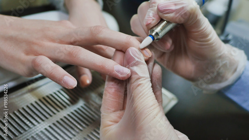 Removing old cover. Woman s hands at manicure procedures