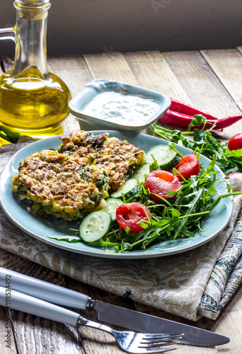 Juicy cutlets on a plate with a salad of tomatoes and arugula