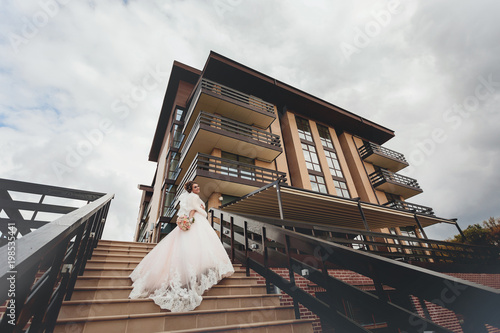 Young beautiful bride posing in front of the modern building