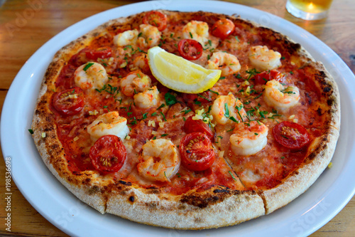 Pizza with shrimps and tomatoes.