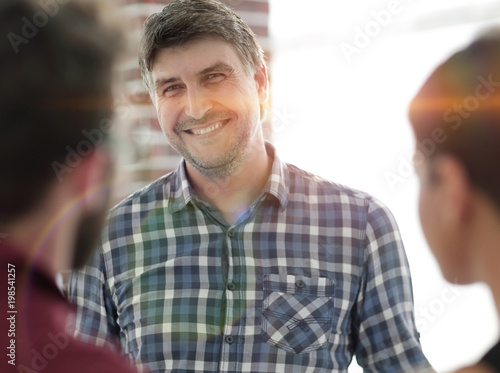Portrait of confident businessman with colleagues  background