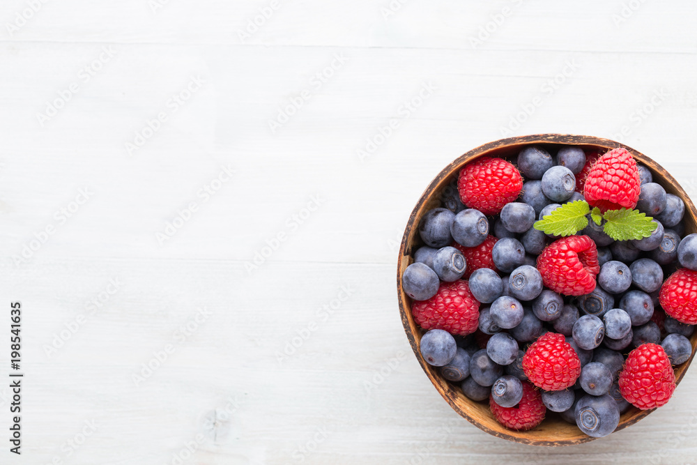 Juicy and fresh blueberries with green mint on rustic blue table. Juicy and fresh blueberries with green mint on rustic blue table.