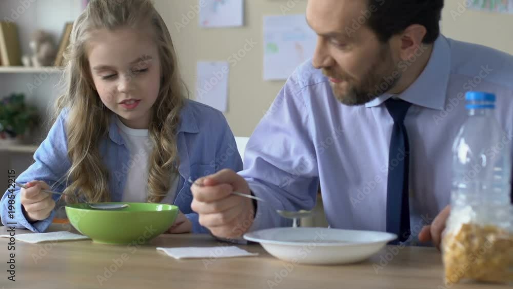 School girl and father eating breakfast in morning, happy time together home School girl and father eating breakfast in morning, happy time together home