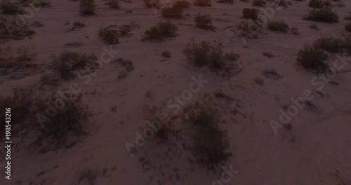 Beautiful pan up sun through rocks fly over - Drone Aerial Video 4K Arizona, Utah, Moab desert, open plain, trail, adventure, discovery landscape, reveal, beautiful, prairie, sun reveal beautiful.