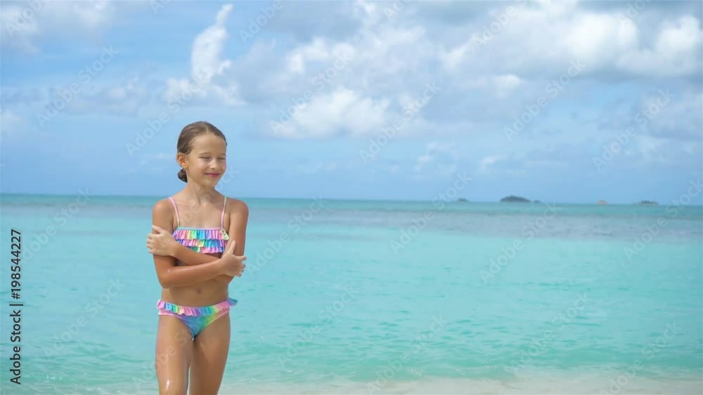 Adorable little girl on the beach. Happy kid enjoy summer vacation Adorable little girl on the beach. Happy kid enjoy summer vacation