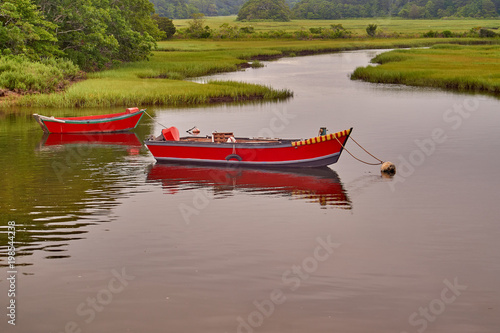 Two small red wooden boats moored in Cape Cod, Massachusetts