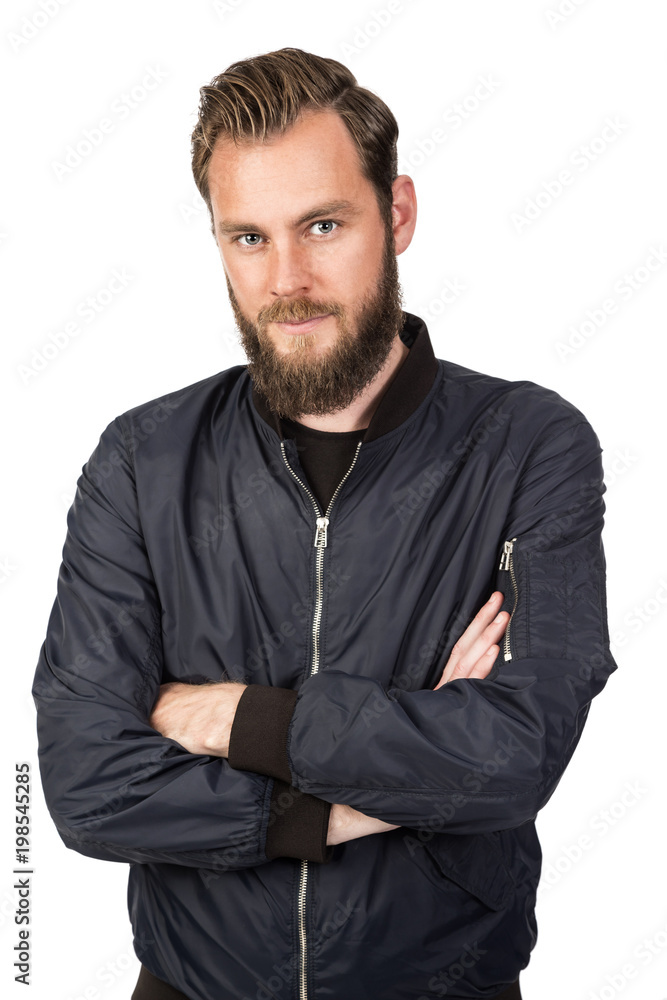 Handsome bearded man standing against a white background wearing a black tshirt and blue jacket in jeans with arms crossed. Looking at camera. Handsome bearded man standing against a white background wearing a black tshirt and blue jacket in jeans with arms crossed. Looking at camera.