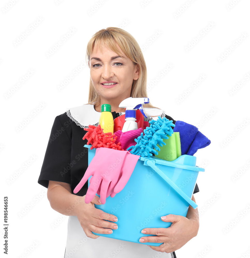 Portrait of mature woman in uniform holding bucket with cleaning supplies on white background Portrait of mature woman in uniform holding bucket with cleaning supplies on white background
