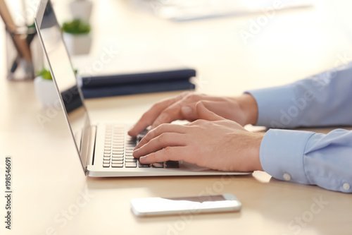 Young man with laptop working in office