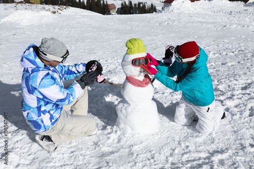 Couple making snowman at sk...