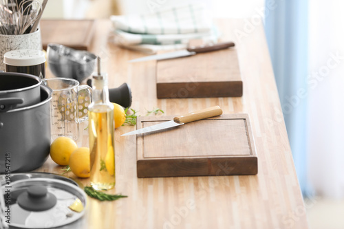 Cutting boards with kitchenware prepared for cooking classes on wooden table