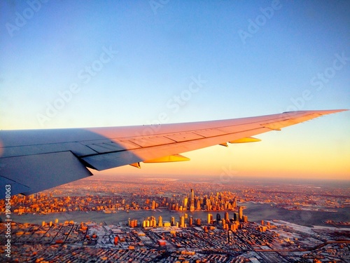 Scenic and impressive aerial view of the New York City Manhattan Skyline (USA) from an airplane during sunset / sunrise on a winter day