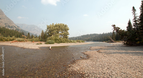 Gravel shoreline of Upper Two Medicines Lake in Glacier National Park during the 2017 fall forest fires in Montana United States