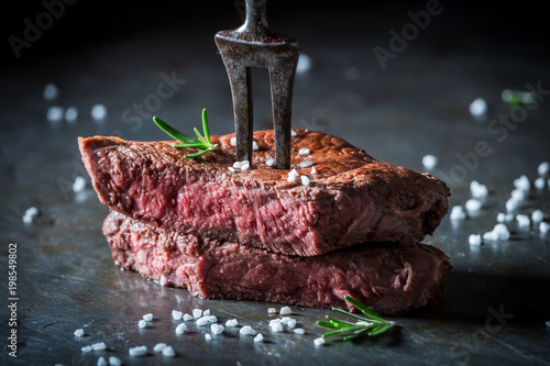Closeup of medium rare steak with salt and herbs