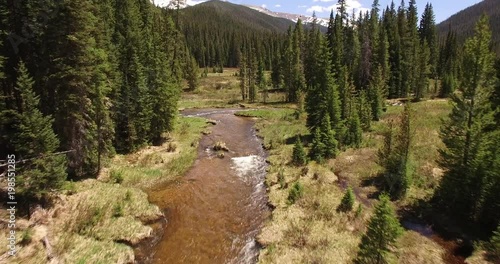 flying into rocky mountin forest low between trees - Drone Aerial Video 4K Colorado Rocky Mountains, Colorado river, Mountain dam at lake granby,  beautiful water reflection, spring, pristine water, 