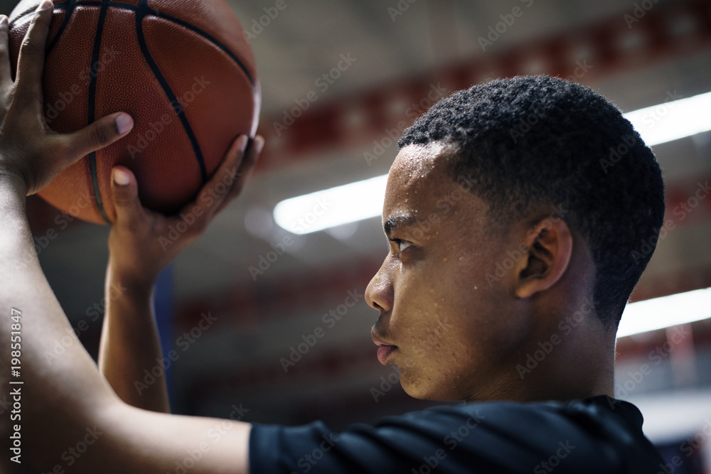 Fototapeta premium African American teenage boy concentrated on playing basketball