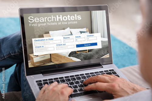 Person Searching Hotels With Low Prices On Laptop