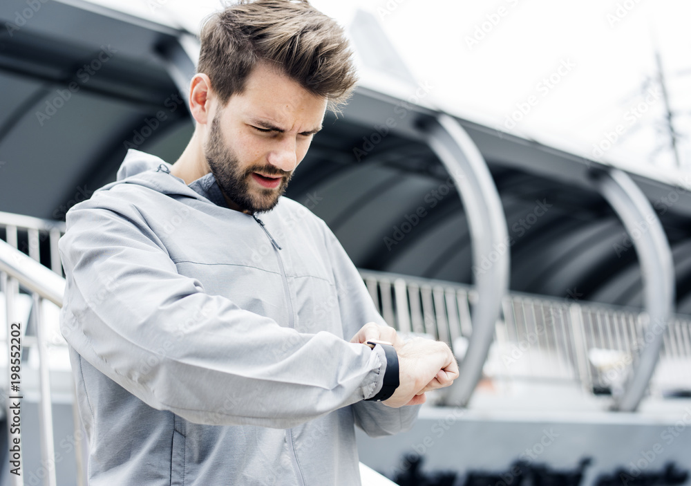 Sporty man looking at his smartwatch