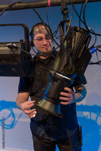 Male theater technician adjusting theatrical lighting units