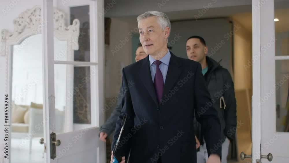 Real estate agent showing an attractive male couple around a property, in slow motion Real estate agent showing an attractive male couple around a property, in slow motion