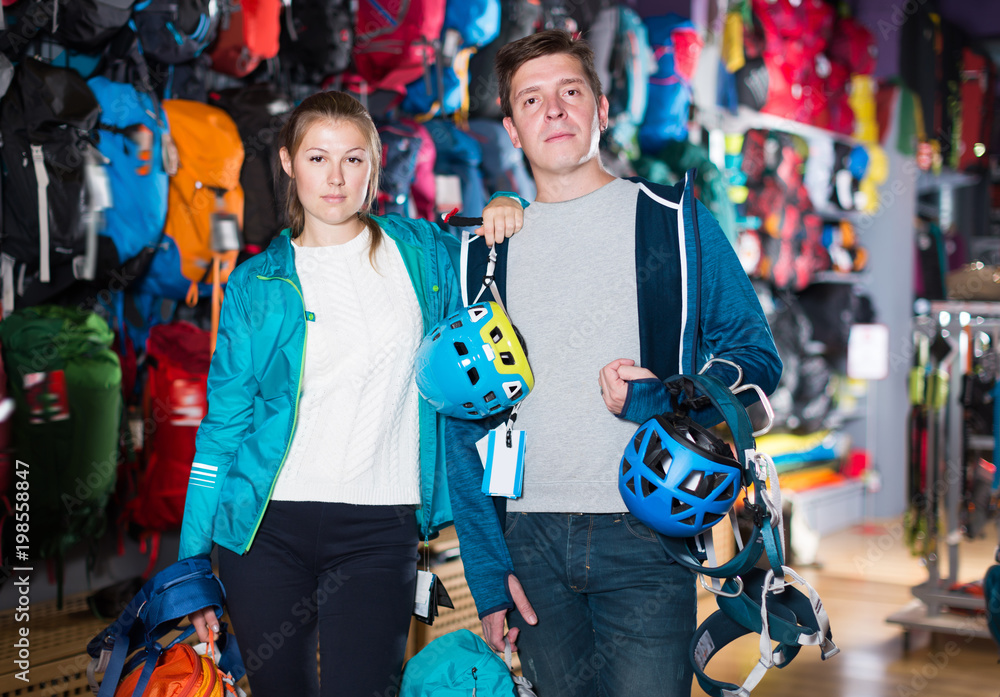 Adult couple is choosing travel gear in shop