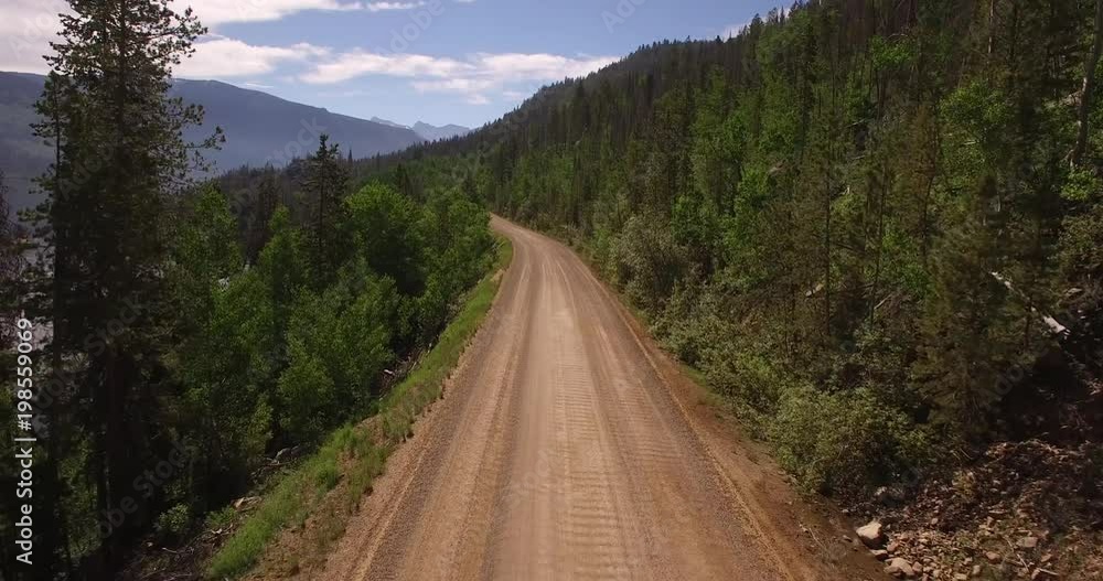Flying down mountain dirt road near lake - Drone Aerial Video 4K Colorado Rocky Mountains, Colorado river, Mountain dam at lake granby, beautiful water reflection, spring, pristine water, foliage, Flying down mountain dirt road near lake - Drone Aerial Video 4K Colorado Rocky Mountains, Colorado river, Mountain dam at lake granby, beautiful water reflection, spring, pristine water, foliage,