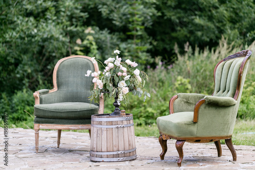 Vintage wood chairs and table with flower decoration in garden. outdoor photo