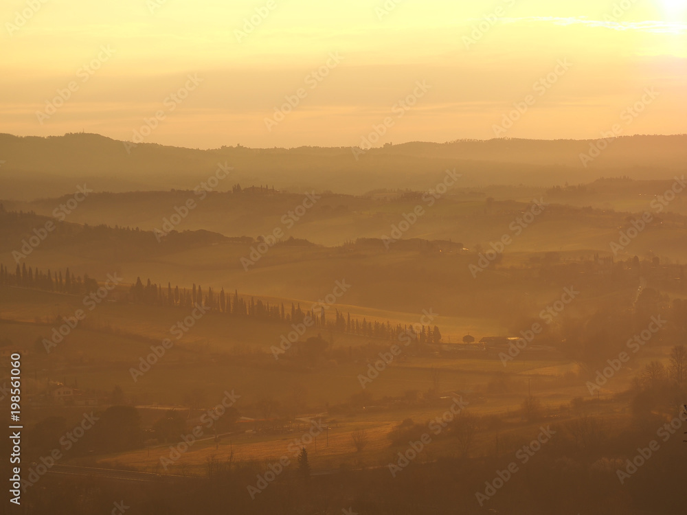 Obraz premium Sunrise in the lands of Tuscany. Warm colors on the hills and haze