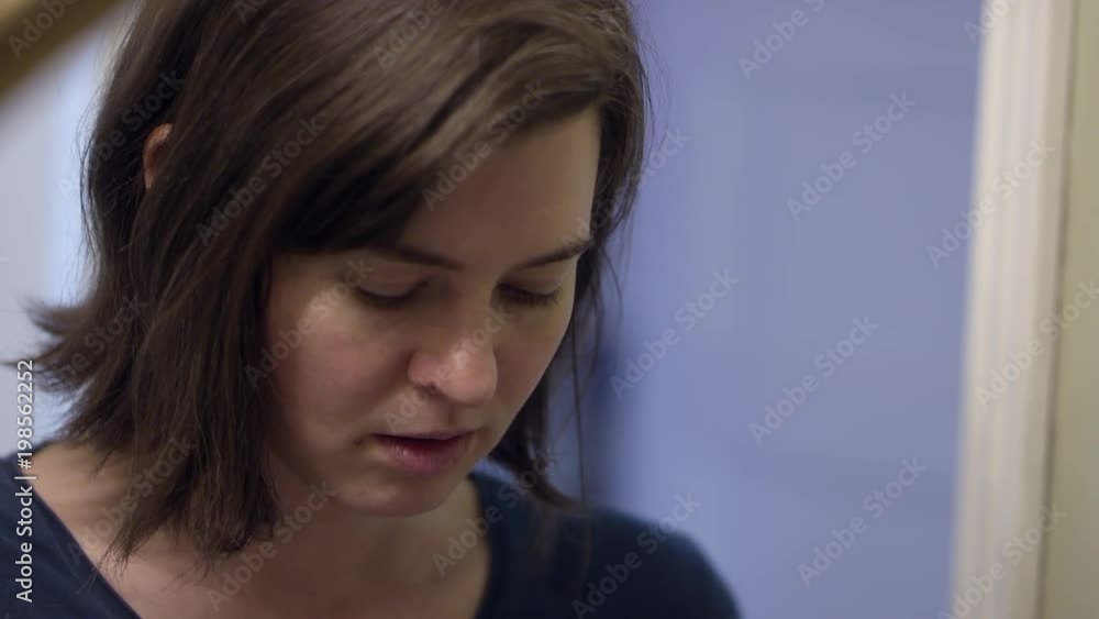 Woman looking at prescription bottle as she has pondering look on her face. Woman looking at prescription bottle as she has pondering look on her face.