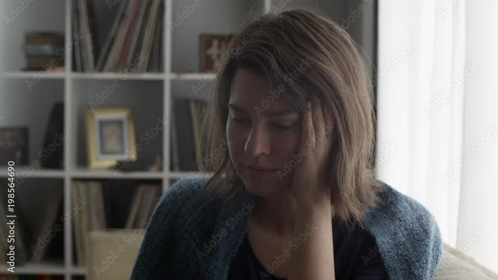 Close up view of woman with stressed look on her face as she puts hand on her cheek. Close up view of woman with stressed look on her face as she puts hand on her cheek.