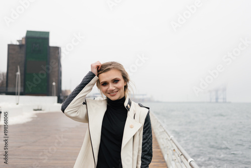 A cute smiling girl posing near the sea.