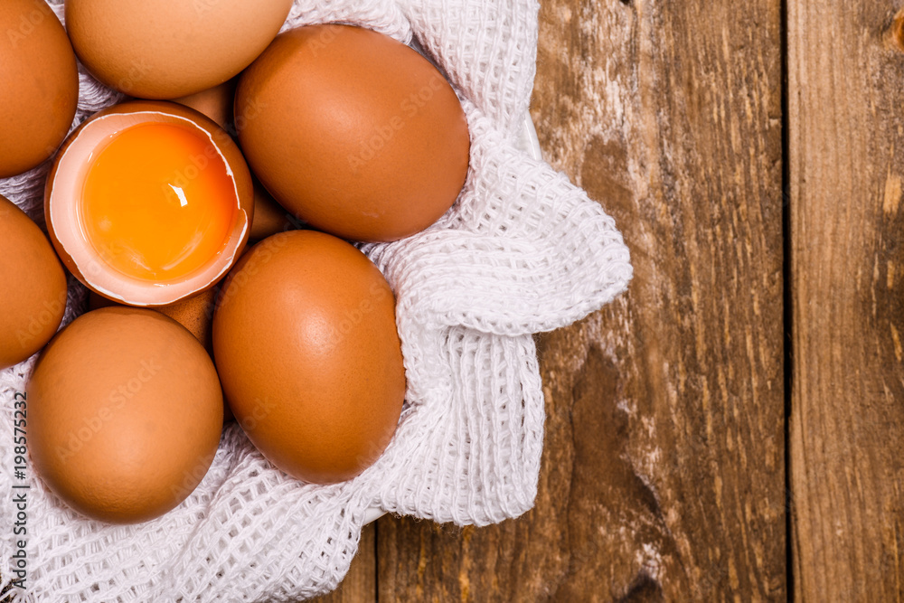 basket with eggs and one broken with egg yolk, with space for text basket with eggs and one broken with egg yolk, with space for text