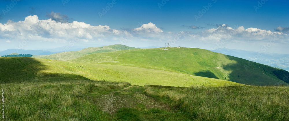on top of green Carpathian mountains range with blue sky on a sunny day, empty landscape background of wide panorama