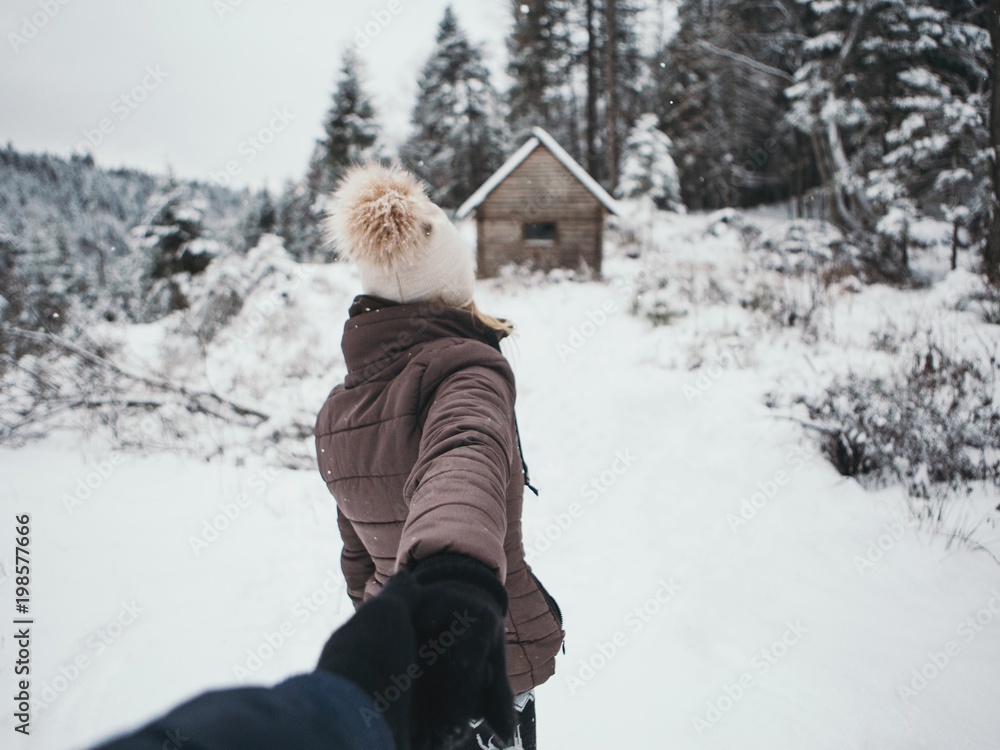 Young couple winter adventures.winter ,Snow isolated.Hold each other hands,girl and her boyfriend walking in forest