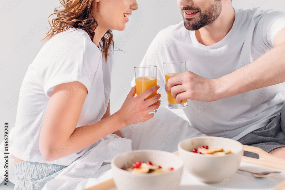 partial view of couple having breakfast in bed in morning together