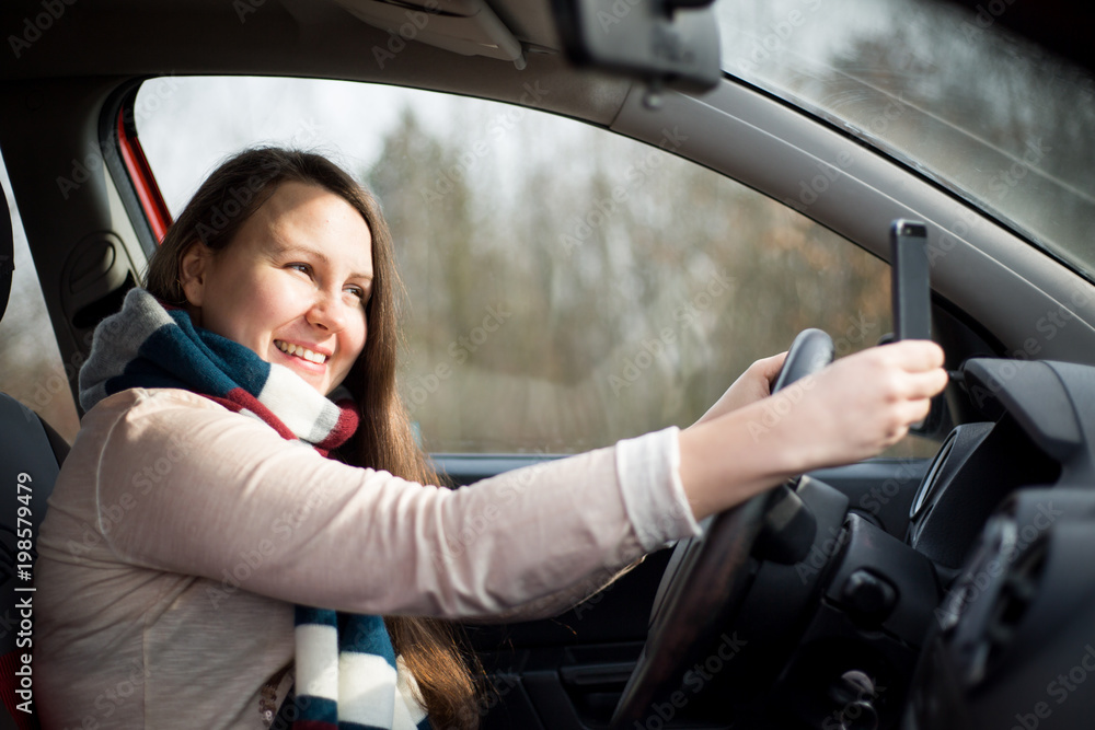 Pretty young brunette woman taking a selfie in the car Pretty young brunette woman taking a selfie in the car
