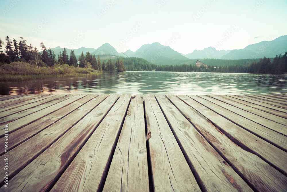 Forest Alpine mountain lake and wooden board background