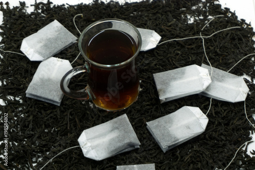 A tea bag in a mug. A mug of tea on the balcony window sill in winter cold. On the glass is a frost. Tea and frosty patterns. A cup of tea in winter against the background of snow. photo