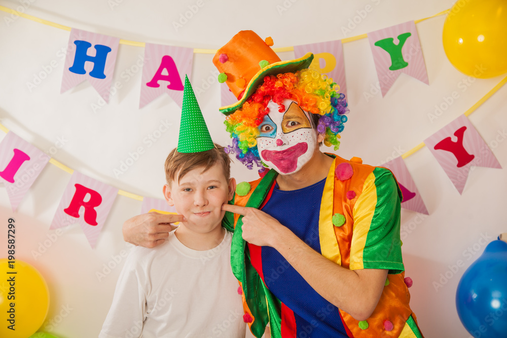 clown boy at the birthday of a child. Party for children. Clowns and an adult guy find a common language clown boy at the birthday of a child. Party for children. Clowns and an adult guy find a common language
